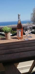 费拉Santo Spiti sou 3的木桌旁的一瓶葡萄酒和两杯酒