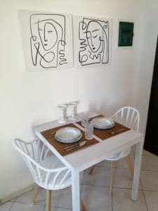 费拉Santo Spiti sou 3的白色餐桌和两把白色椅子
