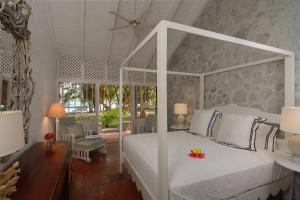 Crescent BeachSugar Reef Bequia - Adults Only的卧室配有白色的天蓬床和庭院。