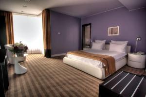 巴克乌杜姆布瓦维酒店的一间卧室设有一张紫色墙壁的大床