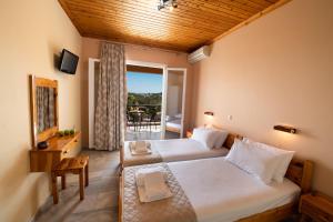 利吉亚Artemis Pension by Imagine Lefkada的酒店客房设有两张床和一个阳台。