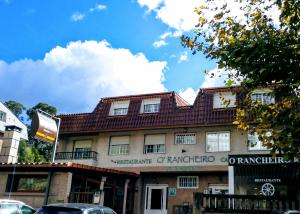 维戈HOSTAL Restaurante RANCHEIRO的街道上一座红色屋顶的建筑
