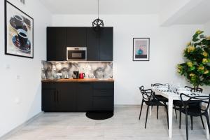 威利兹卡Apartament Solny Centrum Wieliczka 11的厨房配有黑色橱柜和桌椅