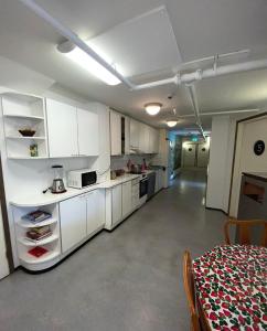 科科拉Hostel400Kokkola的一间厨房,内设白色橱柜和一张桌子