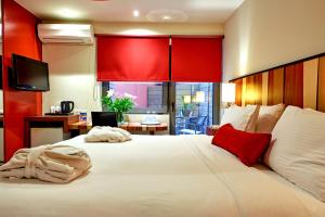 海若克利欧Lato Annex Boutique Rooms的卧室配有红色色调的大型白色床