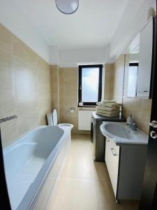 雅西Copou Residence的一间带大浴缸和两个盥洗盆的浴室