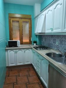 La TobaAlojamiento Rural Casa Inocente的厨房配有白色橱柜、水槽和微波炉
