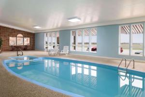 Bethany伯大尼速8酒店的一座游泳池,位于一栋拥有蓝色墙壁和窗户的房屋内