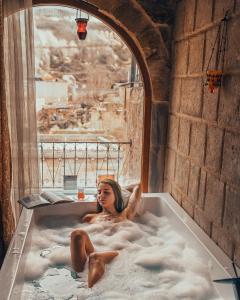格雷梅天使洞穴套房酒店的女人坐在浴缸里