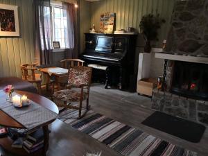 斯泰恩谢尔Yttervik gard的客厅设有壁炉和钢琴。