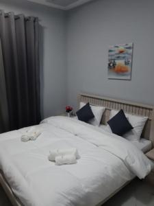 阿吉曼Paris Furnished Apartments - Tabasum Group的一张白色的大床,带两条毛巾
