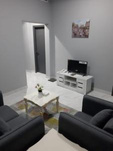 阿吉曼Paris Furnished Apartments - Tabasum Group的客厅配有两张沙发和一张咖啡桌