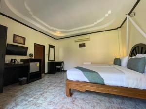 皮皮岛Phi Phi Villa Resort-SHA Extra Plus的一间卧室配有一张床、一张书桌和一台电视