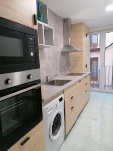 莫利纳德亚拉贡Apartamentos El Cid的厨房配有洗衣机和微波炉。