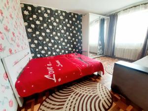 克洛佩夫尼茨基Yanovskogo 3k的一间卧室配有一张红色的床和花卉墙
