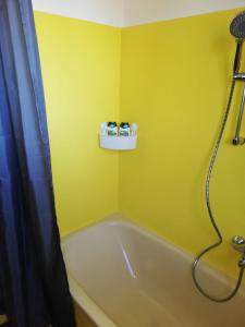 格拉茨Apartment Graz Lustbuhel的黄色的浴室设有浴缸和淋浴。