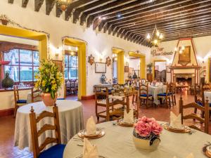 帕茨库卡罗唐瓦斯科贝斯特韦斯特优质酒店的餐厅设有桌椅,并种有鲜花