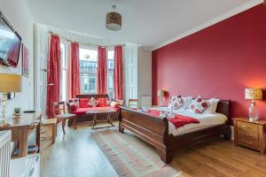 爱丁堡No32 Hotel的卧室设有红色的墙壁、一张床和一张沙发