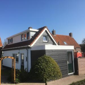 阿赫特克克Pinkeltje的一间白色的小房子,设有车库