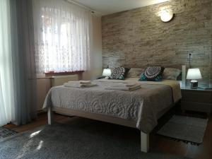 维尔卡瑟Cichy Zakątek的一间卧室设有一张床和砖墙