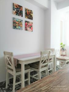 苏恰瓦Cozy Apartment Bujorilor Suceava的白色的餐桌,配有两把椅子和粉红色的柜台