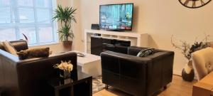 伯明翰Elite luxury apartment的客厅配有2张沙发和1台平面电视