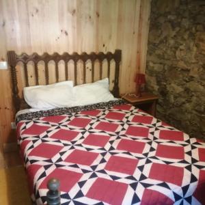 洛萨Casa Branca的一间卧室配有一张带红白色棉被的床