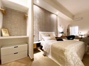 特拉尼Palazzo Bianchi - Trani的卧室配有一张白色大床和一张书桌