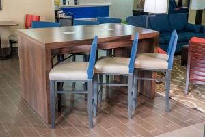 迪克森迪克森康福特茵酒店的一张木桌,四周摆放着两把蓝色椅子