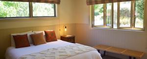 克伦威尔伯恩小屋乡村民宿的卧室配有白色的床和2扇窗户。