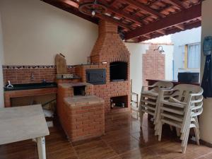 伊利亚孔普里达Casa Azul no Centro Ilha Comprida的厨房配有砖炉和桌椅