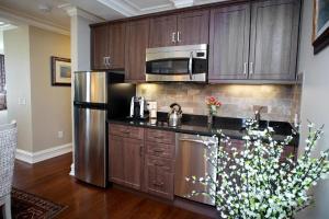 诺沃克Norwalk Inn & Conference Center的厨房配有木制橱柜和不锈钢冰箱。