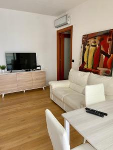 阿尔盖罗Ada's House的客厅配有白色沙发和平面电视。