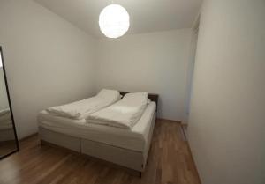 卑尔根Nice, Modern Apartment in Central Bergen的一间白色的小卧室,配有一张床和一个光线
