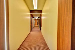 钦奈FabHotel Nestlay Rooms Airport的一条走廊,一条黄色的墙壁和一条长长的走廊