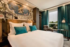 巴黎巴黎金门一号汽车旅馆的卧室配有带蓝色枕头的大型白色床