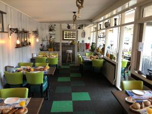 巴勒哈姆斯泰德Pension Even Buiten的用餐室配有桌子和绿色椅子