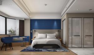 南昌南昌八一广场智选假日酒店的一间卧室设有一张床和蓝色的墙壁