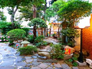 木浦市Gallery Family Hotel的一座种有树木和石头人行道的花园