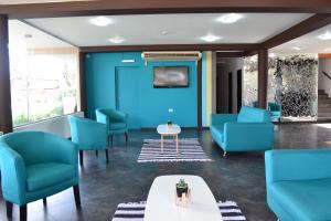 维拉卡洛斯帕兹Hotel Montana by CPH的一间设有蓝色椅子和桌子的等候室