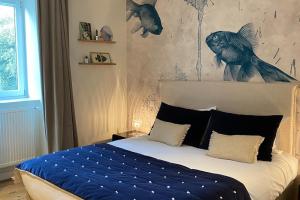 圣马洛圣拉斐尔别墅旅馆的卧室配有一张壁挂鱼壁画的床