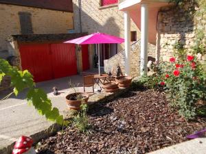 萨尔拉拉卡内达旭日民宿的一个带粉红色雨伞和一些植物的庭院