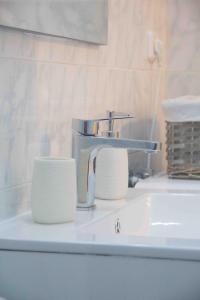 科莫蒂尼Nikoletta's Studio 2的浴室水槽配有水龙头和两堆纸质毛巾