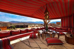 拉拉塔可库斯特Kalyptus Luxury Camp的庭院设有红色的沙发、桌子和椅子