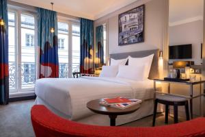巴黎马丁巴黎Spa酒店的酒店客房配有一张床铺和一张桌子。