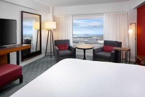 波士顿波士顿港凯悦酒店的酒店客房设有床、椅子和大窗户。