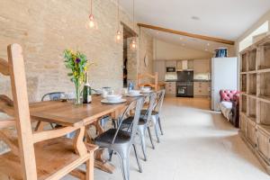 DyrhamMiddle Barn的厨房以及带木桌和椅子的用餐室。
