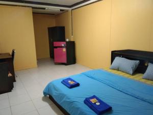 坤西育府E2S Place的一间卧室配有两张带蓝色床单的床和冰箱