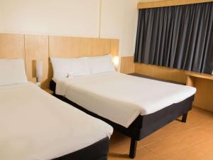 马塞约ibis Maceio Pajuçara的酒店客房设有两张床和窗户。