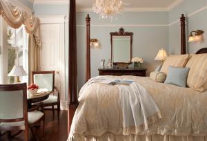 波因特普莱森特海滩塔楼小屋住宿加早餐旅馆的一间卧室配有一张床、一张桌子和一面镜子